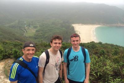 Liam (middle) with, his dad and brother, on a hike with one of Hong Kong's many beaches in the background.&nbsp;